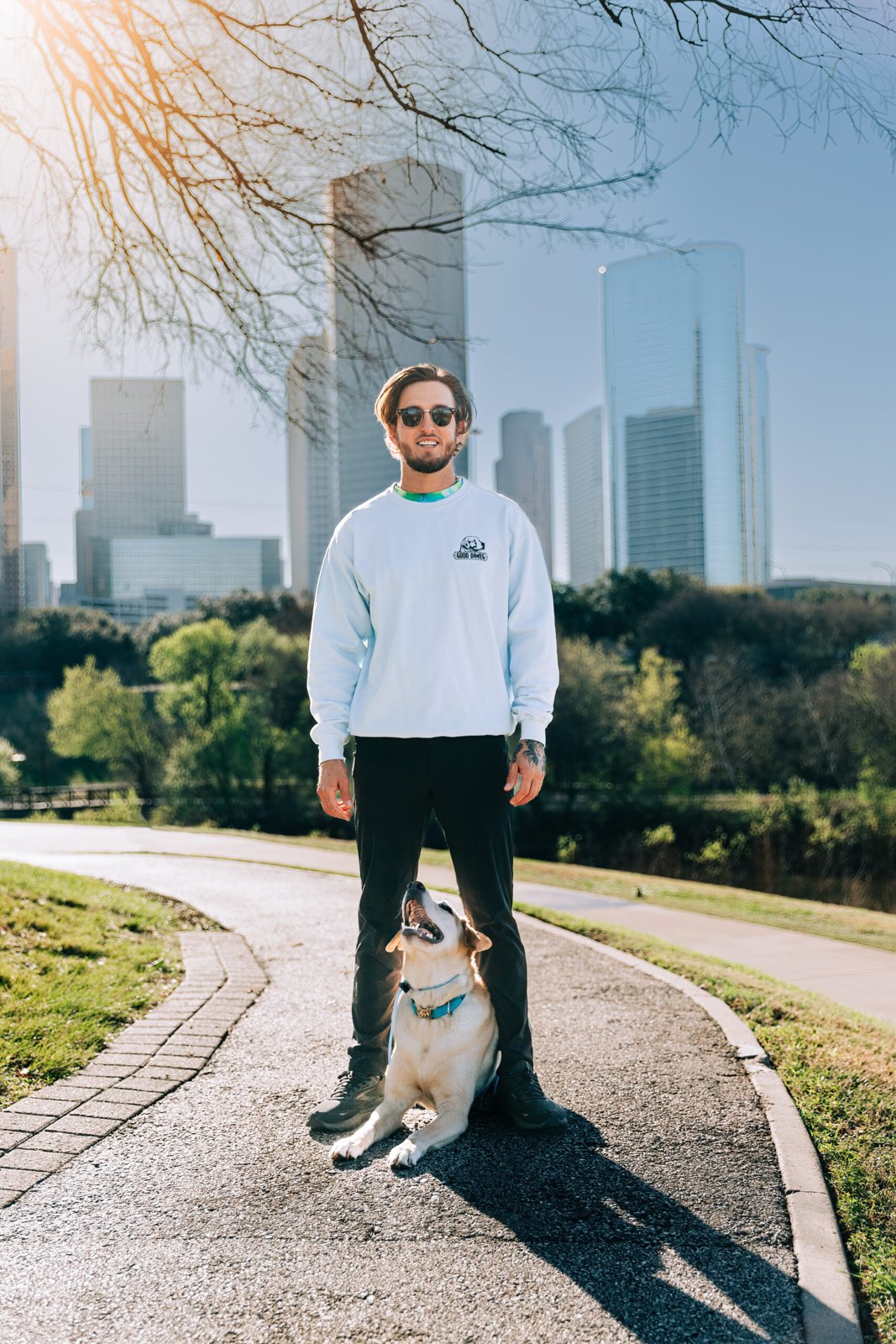 Wesley Dawe and a dog on a trail with Houston buildings behind them